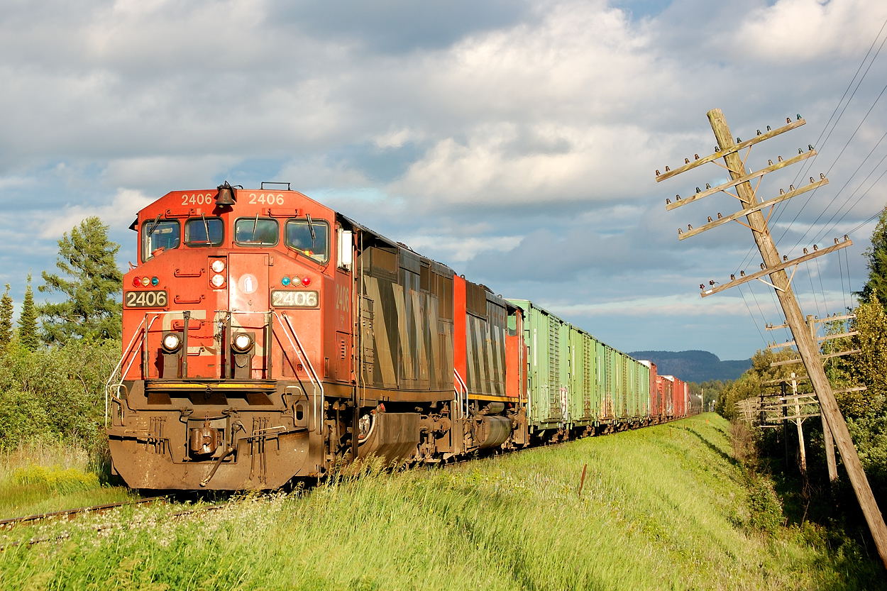 Departing Thunder Bay with the Norwester Mountains as the backdrop, CN A437 enters the OCS at SNS Evans with a pair of cowl units in the form of C40-8M 2409 and an unidentified SD60F trailing. Something off about this edition of this train is the lack of grain empties- likely due to the mid week Canada Day holiday- the train is mostly comprised of boxcar loads of paper from the local Abitibi-Bowater paper mill accompanied by residue tank cars from "Petro-Canada".