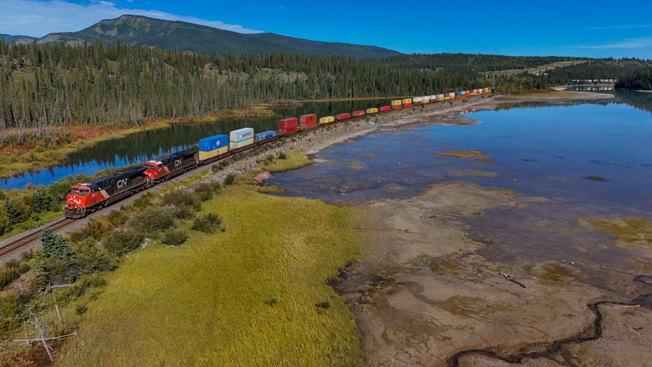 Q 18521 13: CN 3803, CN 3248 rolls along the shore of the Athabasca River with 186 cars.