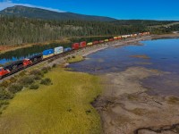 Q 18521 13: CN 3803, CN 3248 rolls along the shore of the Athabasca River with 186 cars. 