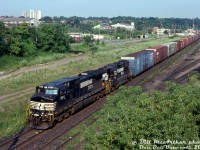 NS C44-9W 9411 and GP38AC 4121 roll #328 (autoparts train from St. Thomas to Buffalo) through CN's Stuart St. Yard on a sunny morning. The CN freight shed and diesel shop are visible in the background, both had seen better days. The old Rheem warehouse is also visible amid the overgrown foliage and industrial scenery.
<br><br>
While a <a href=http://www.railpictures.ca/?attachment_id=47680><b>new GO station and CN transloading facility</b></a> have set up shop here in more recent years, all the empty lots and demolished factories make it seem like a bit of a deindustrialized wasteland.
<br><br>
<i>Bill McArthur photo, Dan Dell'Unto collection slide.</i>