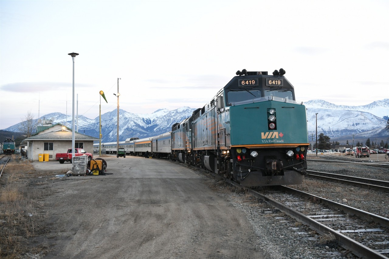 VIA 6419 is on the point of VIA 001 The Canadian at Jasper, AB on this very cold and breezy March 1st early morning. The sun has not yet risen over the peaks surrounding the CN yard. 
A single stand-by locomotive rests on the backtrack at the very left of the frame.