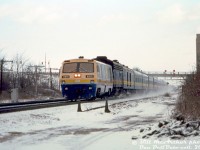 One of Bill McArthur's more frequented photo spots was at Aldershot just west of the Aldershot Cold Storage building (probably due to easy trackside parking in the colder months). On a wintery February day in 1984, VIA LRC 6901 heads an ex-CN 6600-series F9B with a string of blue and white passenger cars westbound through Aldershot. The low-slung profile of the newer LRC locomotive looks somewhat odd pared with the standard-height B-unit and passenger cars.<br><br><i>Bill McArthur photo, Dan Dell'Unto collection slide.</i>